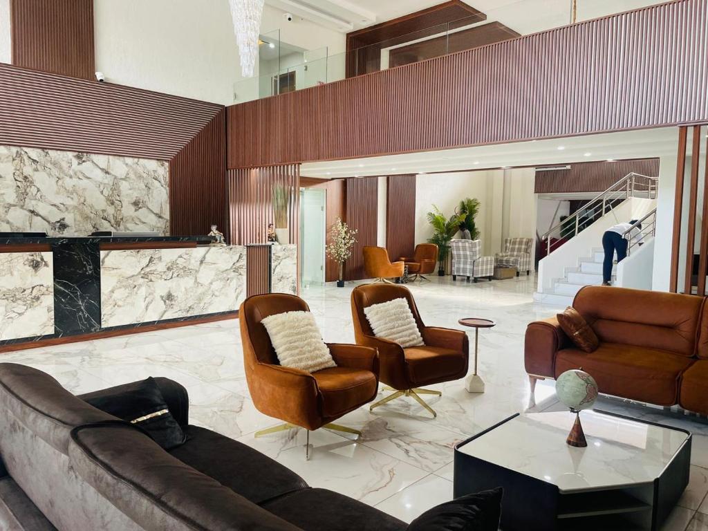 TulunLIA hotel- Lungi International Airport的带沙发和椅子的客厅以及壁炉