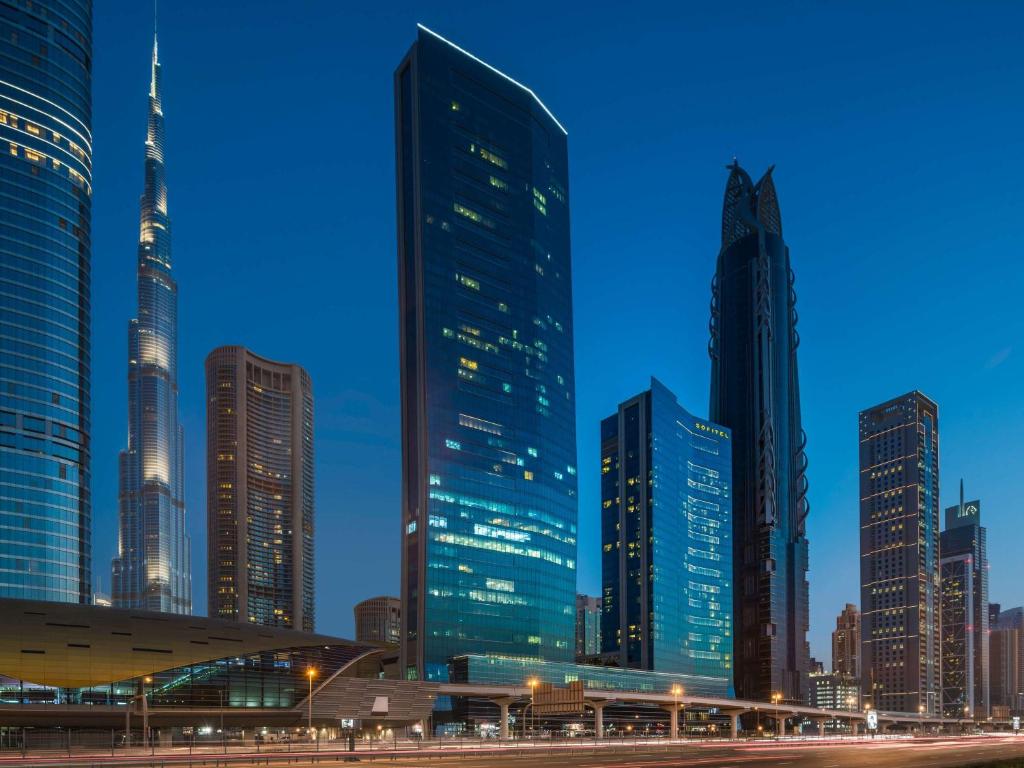 迪拜迪拜市区索菲特酒店的城市天际线,夜晚有高耸的摩天大楼