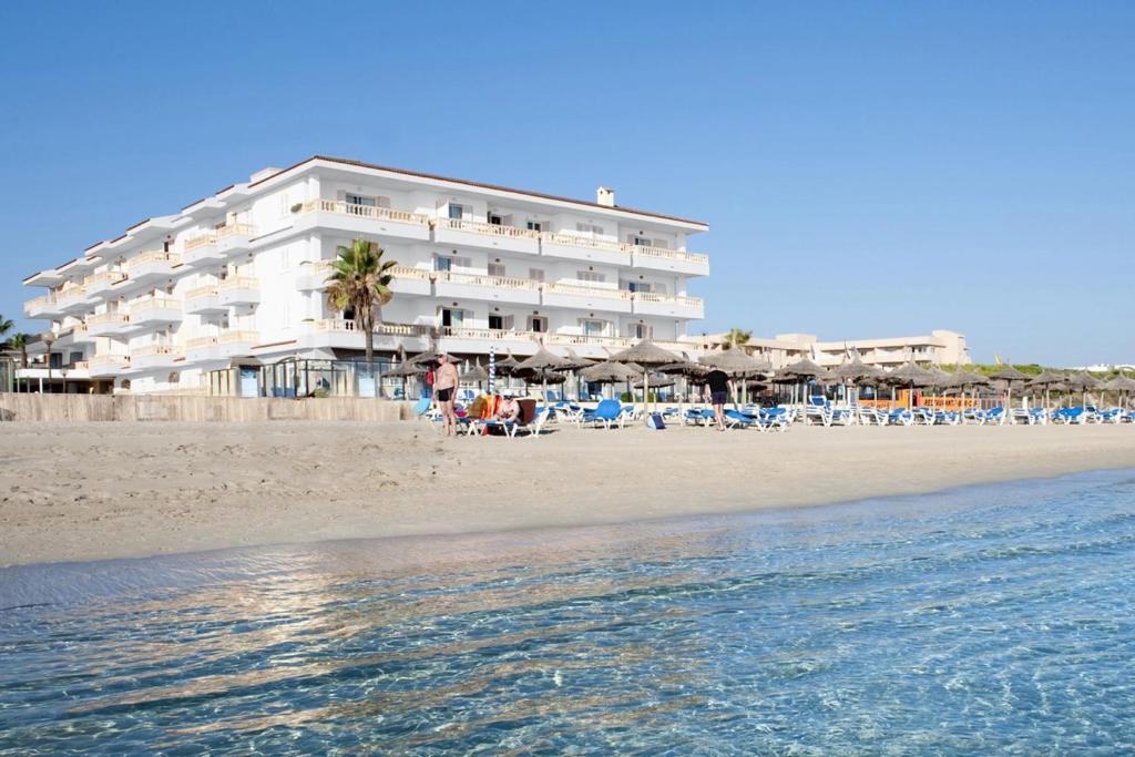 坎皮卡福特Grupotel Dunamar的海滩上的酒店,配有椅子和遮阳伞