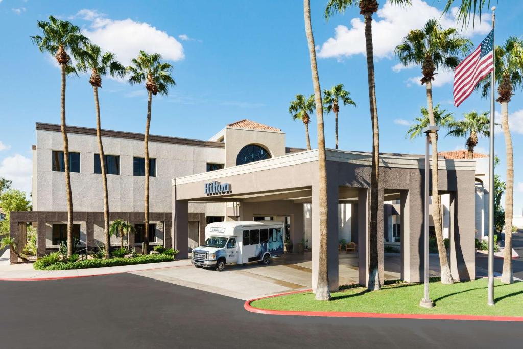 凤凰城凤凰机场希尔顿酒店的停在棕榈树建筑前面的卡车