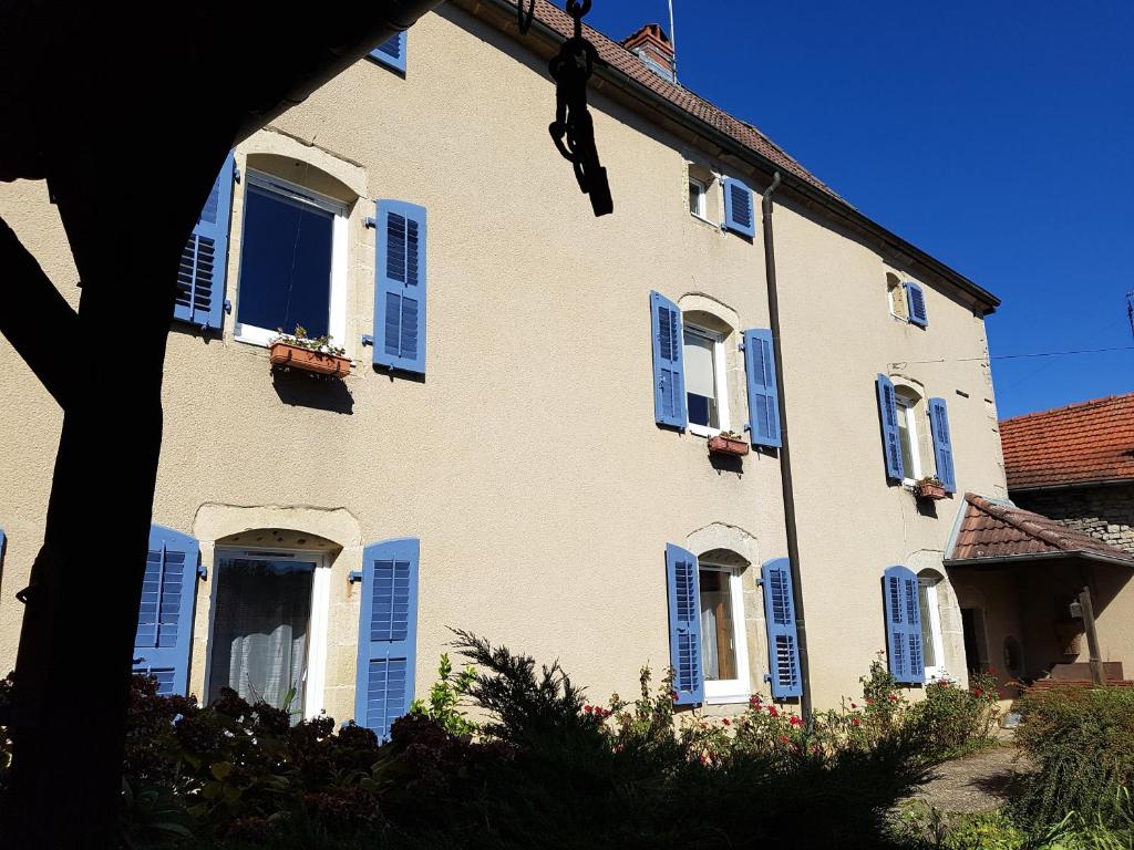 Anchenoncourt-et-ChazelLa Grange Des Roches Roses的蓝色百叶窗的大房子