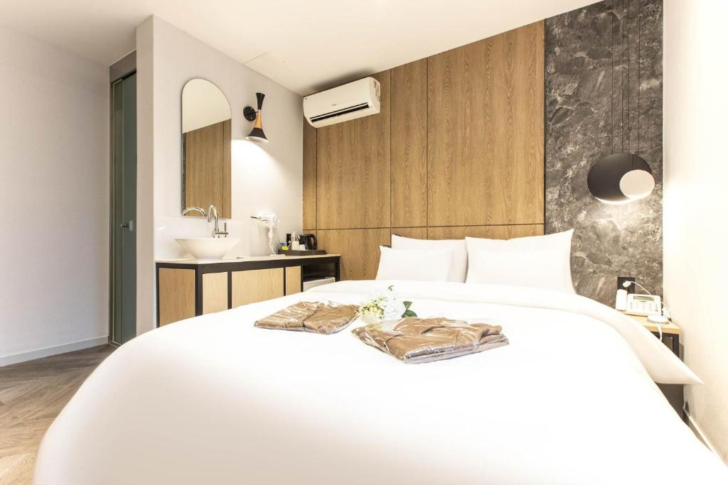 仁川市Brown Dot Hotel Incheon Jakjeon的卧室配有白色的床和水槽