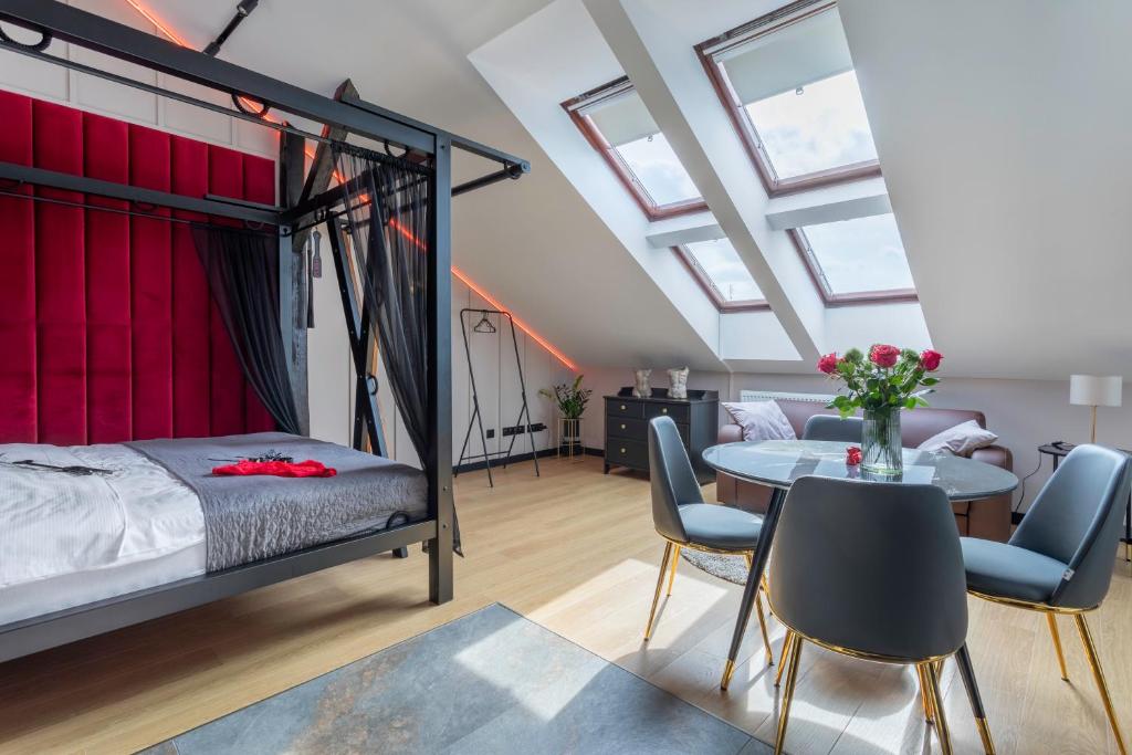 克拉科夫Exclusive BDSM Apartment Kraków - ADULTS ONLY的卧室配有一张床和一张桌子及椅子