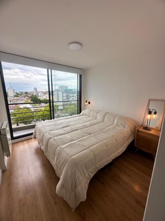 巴尔卡塞nardos suites的一张大床,位于带大窗户的房间里