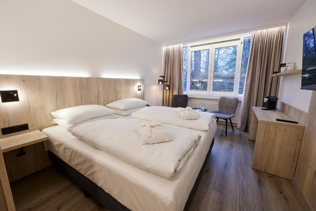 埃森佈雷登尼酒店的一间卧室配有一张带白色床单的大床