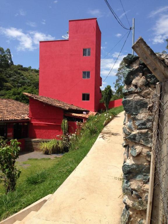 圣巴巴拉Pousada Maria Francisca的一条红楼,旁边是一条路,有石墙