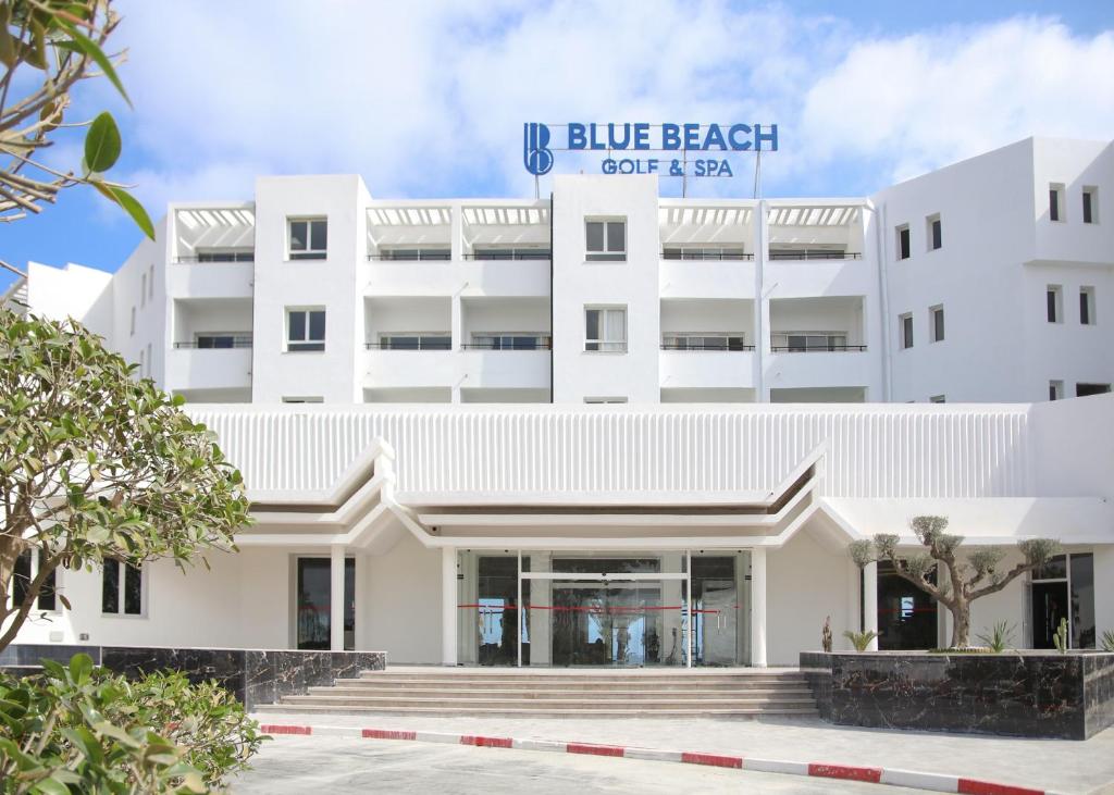 莫纳斯提尔Blue Beach Golf and Spa的白色的建筑,设有蓝色的海滩咖啡厅和水疗中心