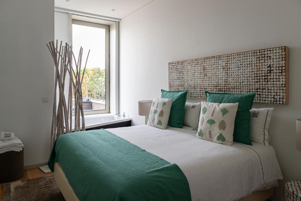 波尔图Porto Deluxe Palace的一间卧室配有一张带绿色枕头的大床