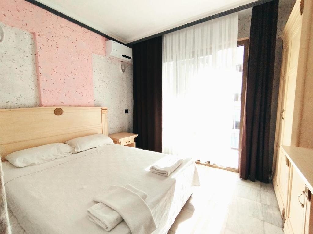 库萨达斯NESCLASS OTEL的卧室配有白色的床和窗户。