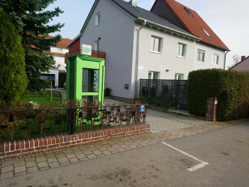 巴特温茨海姆Ferienwohnungen Flora的前面有一个绿色电话亭的房子