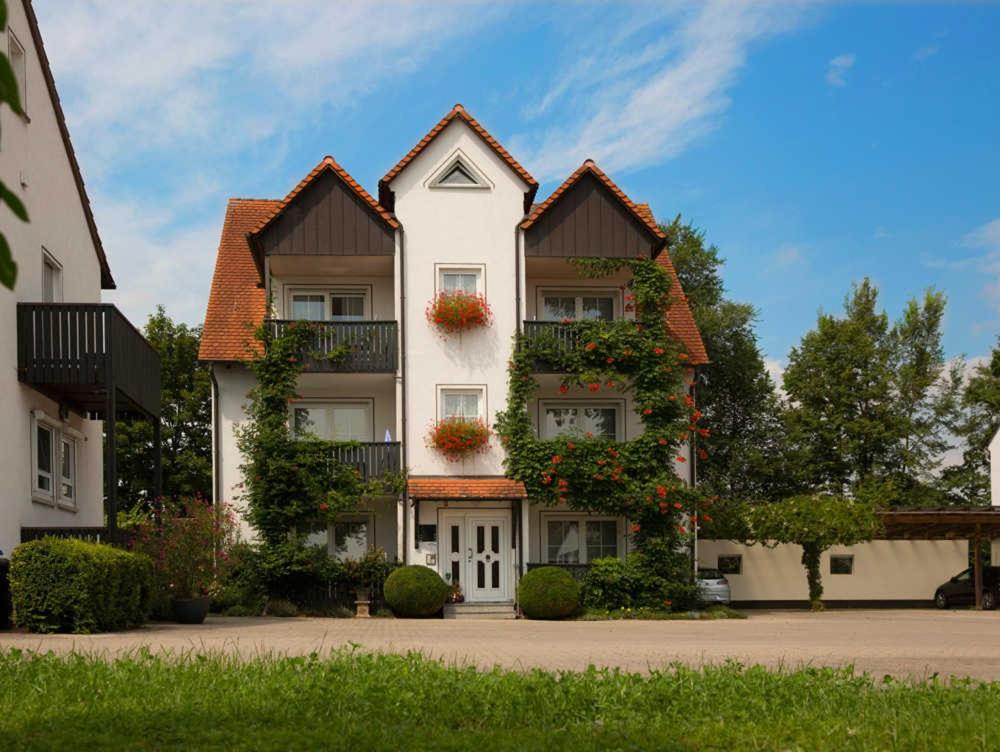 巴特温茨海姆Kur & Golf Ferienwohnungen Wattenbach的一座大型白色建筑,有两个屋顶