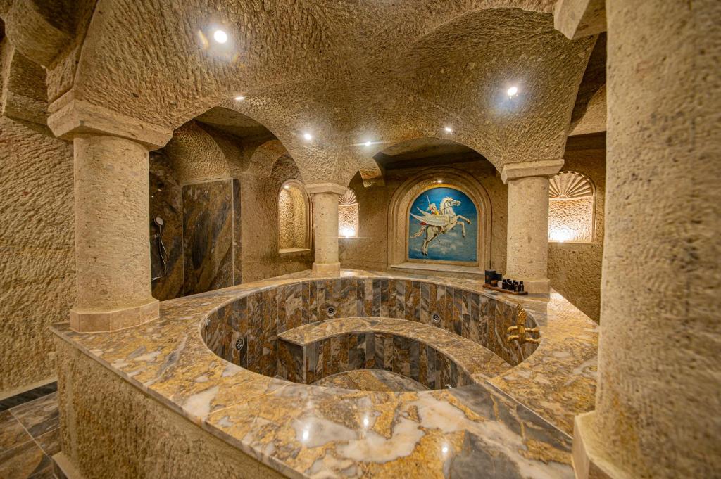 格雷梅Ares Cave Suites的一间大型石头客房,中间有一个大碗