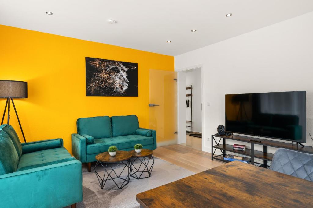 沃尔夫斯堡FREE LIVING - Jungle Design Apartments, Zentrum, Parkplatz, Küche, Wlan的客厅配有2张蓝色沙发和电视