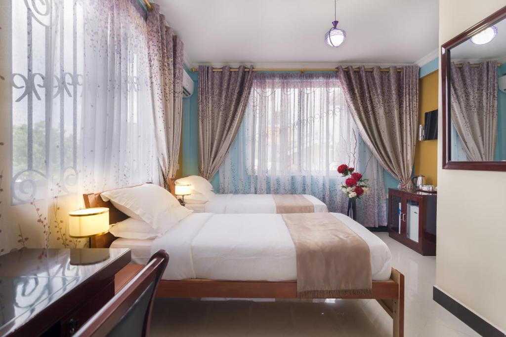 MbuguniNew Mazubu Grand Hotel Mererani的酒店客房设有床和窗户。