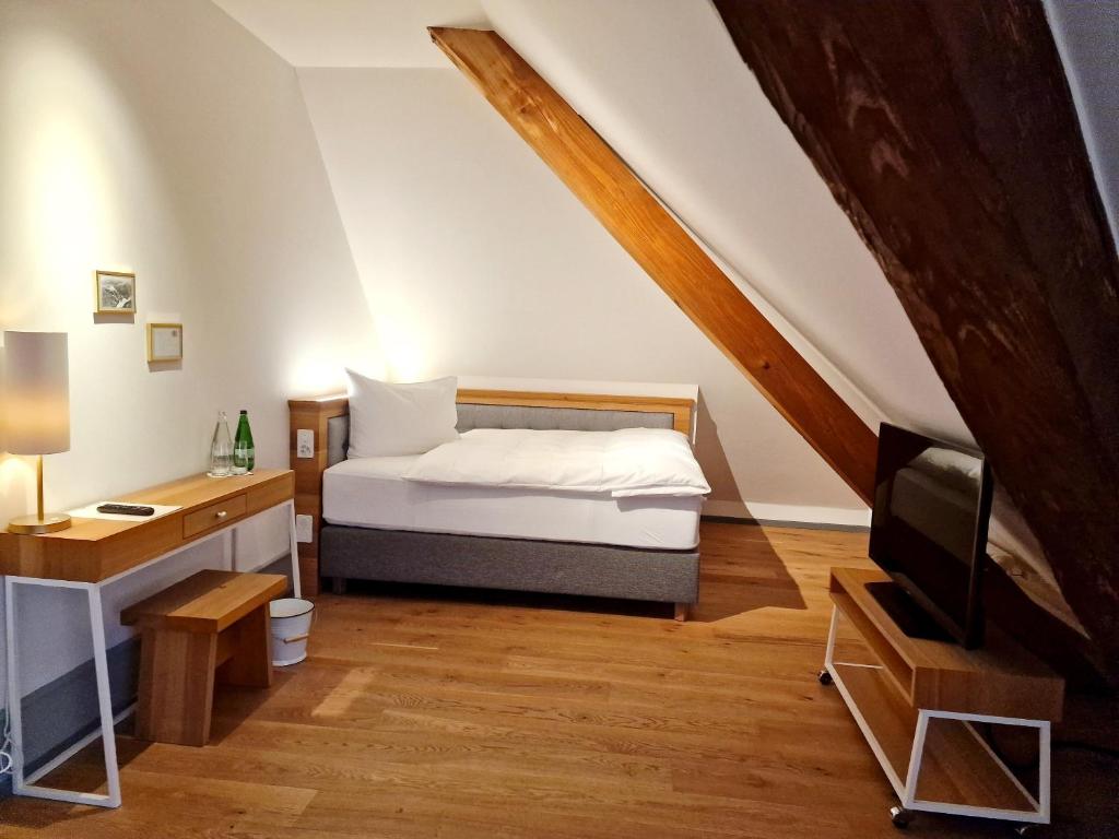 OberdorfHotel Weissenstein的一间卧室配有一张床、一张书桌和一台电视