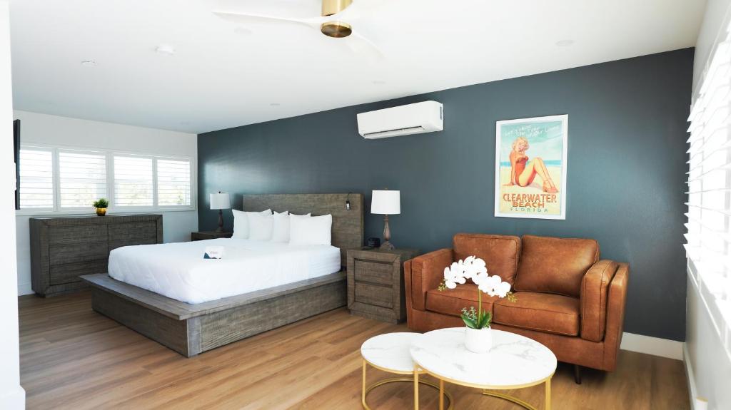 克利尔沃特Ivory Sands Beach Suites的一间卧室配有一张床、一张沙发和一张桌子