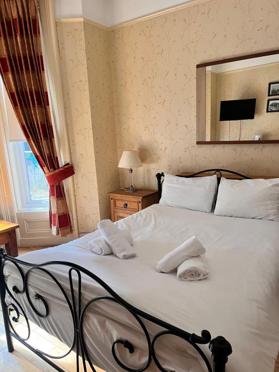 利物浦比奇格罗夫山套房酒店的一间卧室配有一张床,上面有两条毛巾