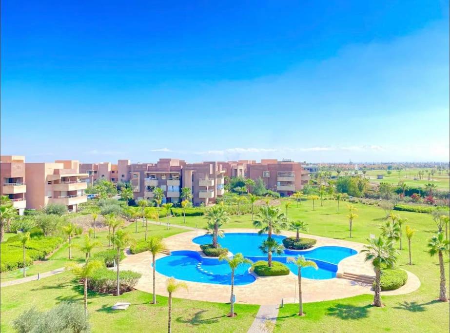 马拉喀什Prestigia Golf entrée Agate (wifi)的享有度假村的空中景致,设有游泳池和棕榈树