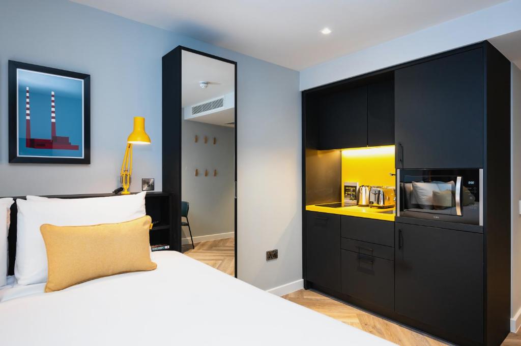 都柏林Staycity Aparthotels Dublin City Centre的一间卧室设有一张大床和一个黄色的柜台。