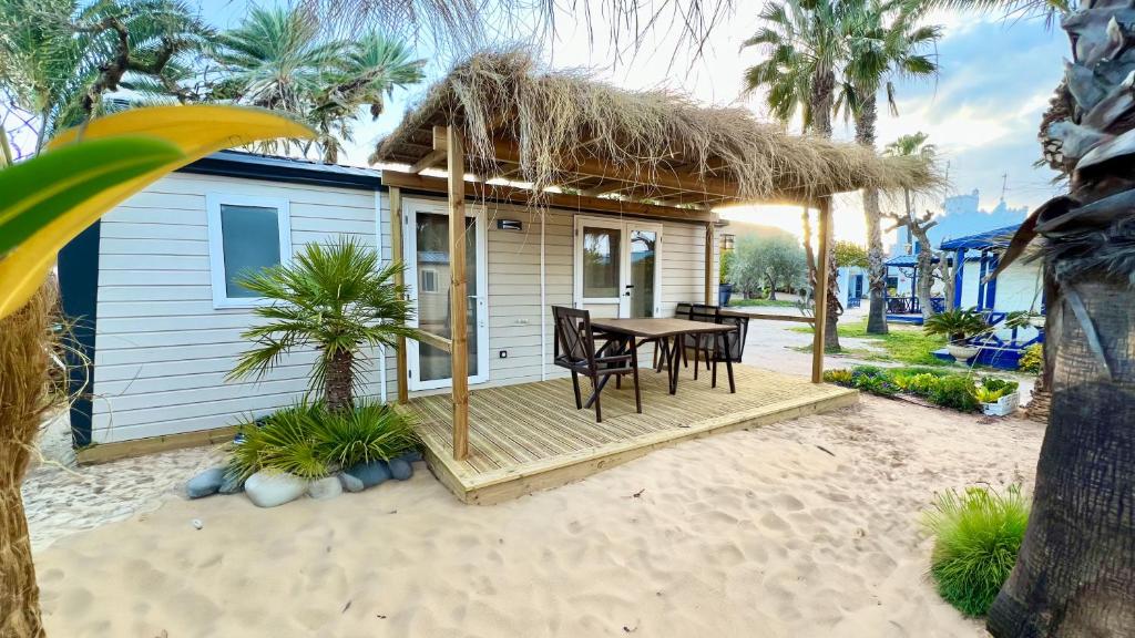 莱斯卡瑟斯-达尔卡纳Cámping & Bungalows Estanyet的海滩上的小房子,配有桌椅
