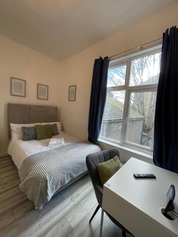 伦敦Camberwell Living Studio - Zone 2 London的一间卧室配有一张床、一张书桌和一个窗户。