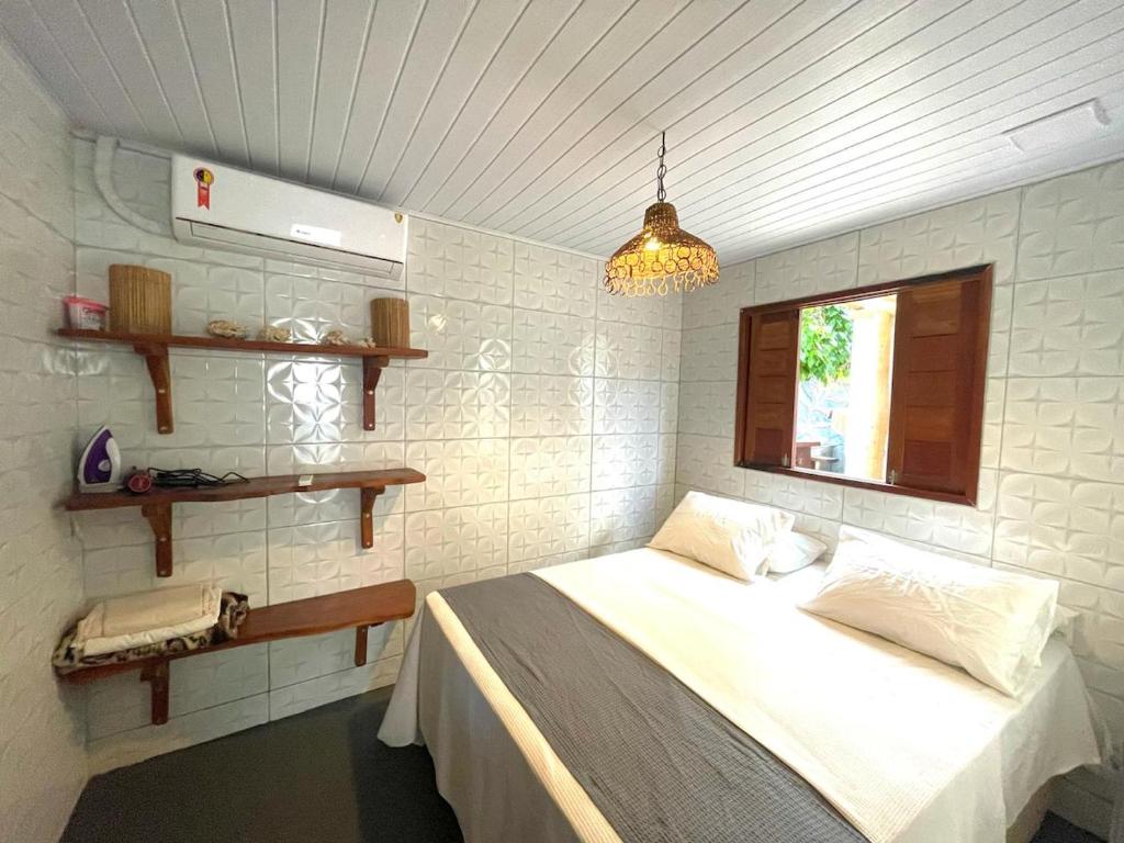 圣米格尔-杜斯米拉格里斯Chalé Palhano Beach的一间卧室设有一张床和一个窗口