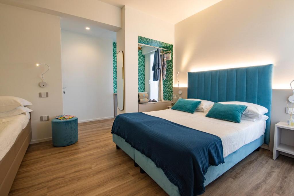 马洛塔UNAWAY Imperial Beach Hotel的一间卧室配有一张大床和蓝色床头板