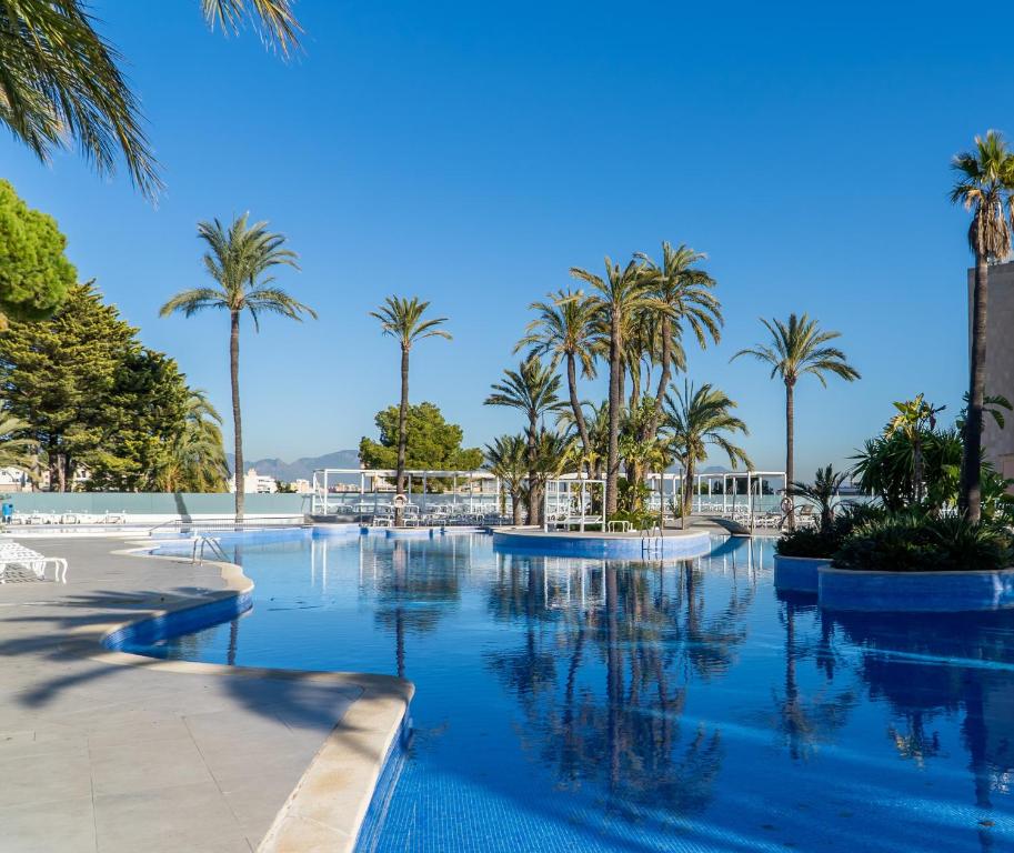 马略卡岛帕尔马GPRO瓦尔帕莱索宫温泉酒店的度假村内棕榈树游泳池