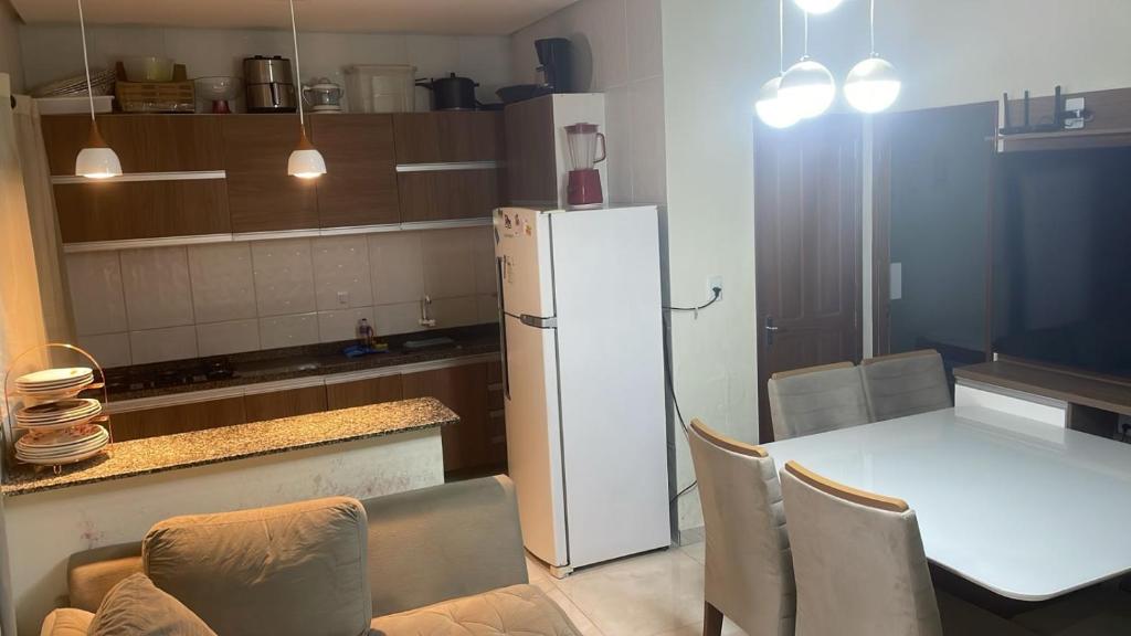 马瑙斯Casa 2 Quartos Manaus的厨房配有桌子和白色冰箱。