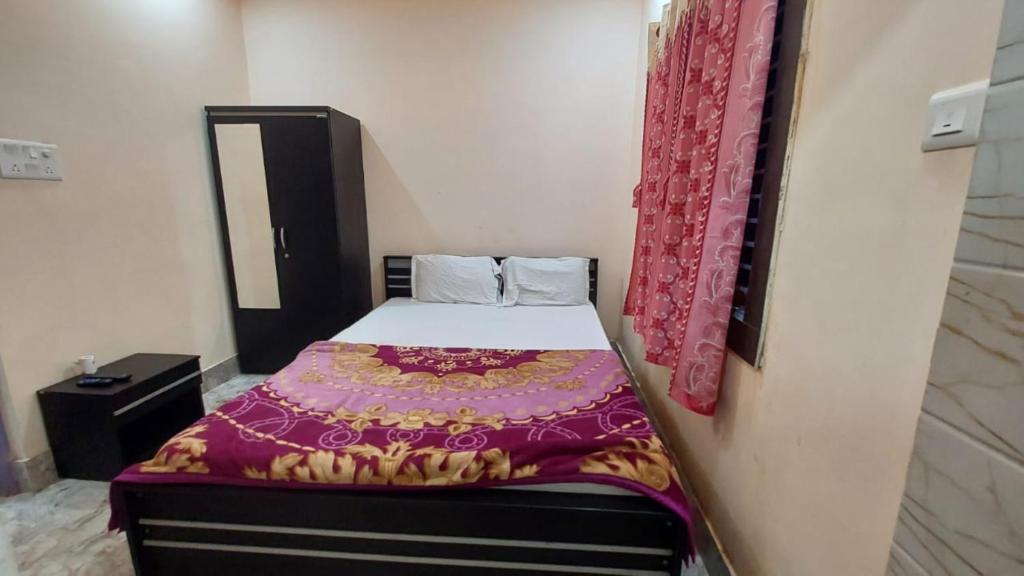 普里GRG M S M Residency Puri的一间小卧室,配有一张带紫色毯子的床