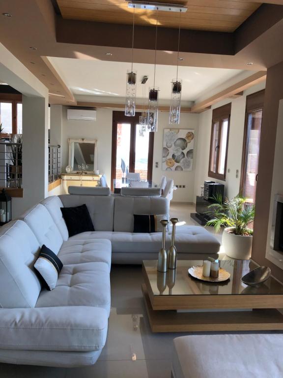 卡兰巴卡Villa Under Meteora的客厅配有白色的沙发和桌子