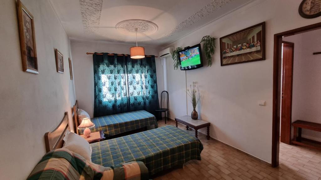 波尔蒂芒Santa Isabel的一间带两张床和电视的客厅