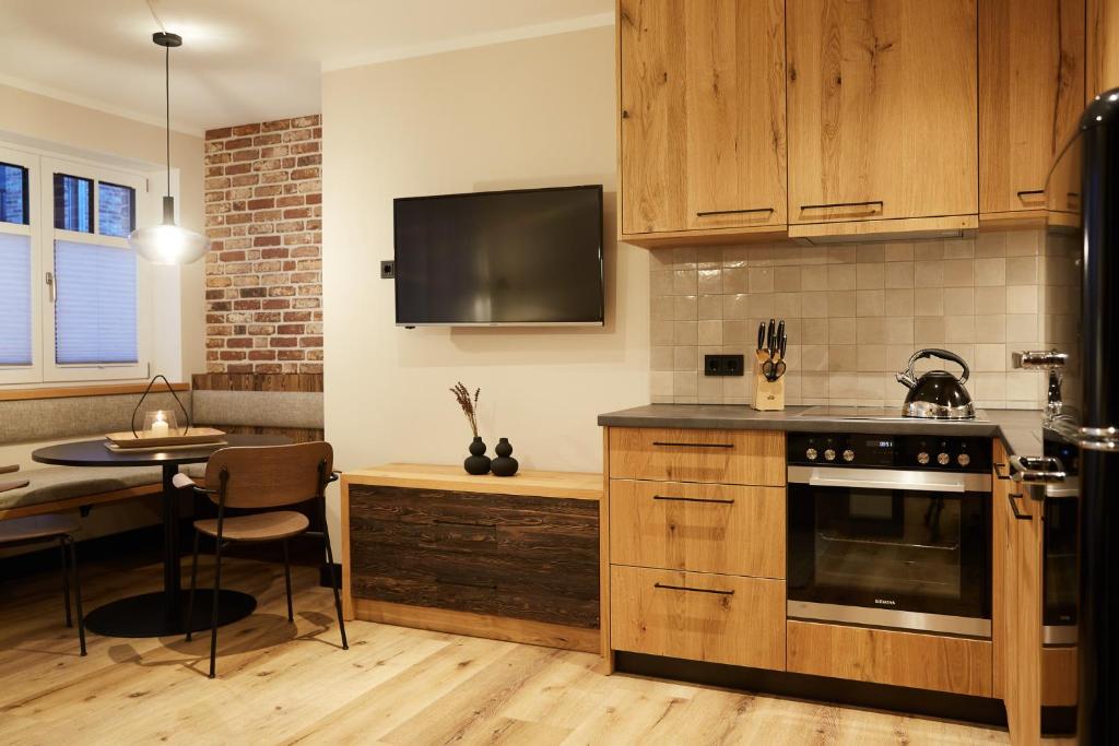 比苏姆Binnendiek Haus 6 Apartment 2的厨房配有木制橱柜、桌子和台面
