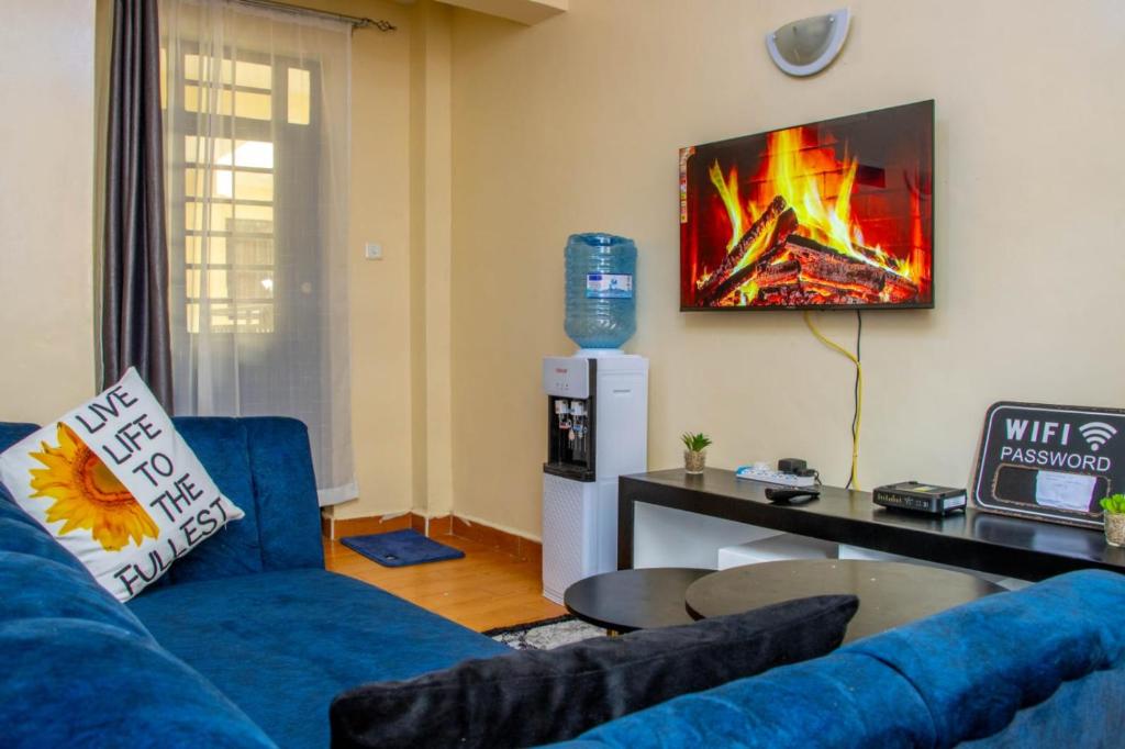 内罗毕AirBnB的客厅配有蓝色的沙发和墙上的壁炉