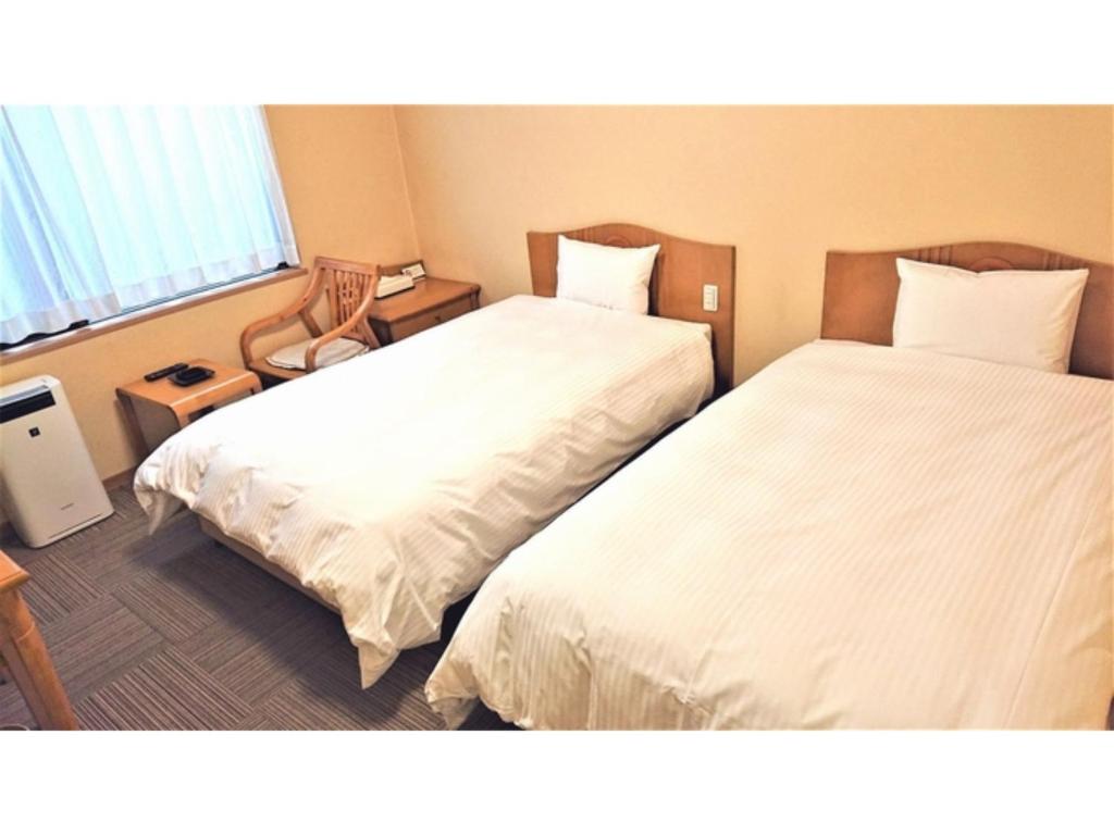 音更町Hotel Hounomai Otofuke - Vacation STAY 29507v的配有白色床单的酒店客房内的两张床