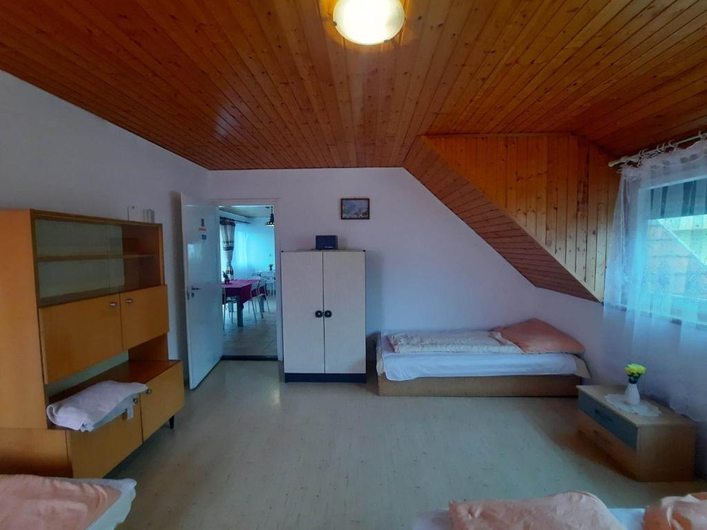 包道乔尼托毛伊Badacsonyi családi privát házak的一间卧室设有两张床和木制天花板