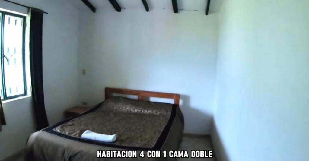 SutamarchánFinca Hotel的窗户客房内的小床