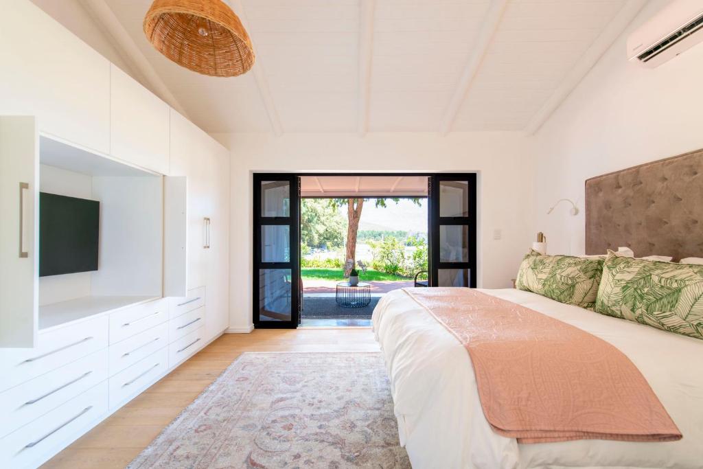 弗朗斯胡克Franschhoek Cottages的一间卧室配有一张大床和一台平面电视