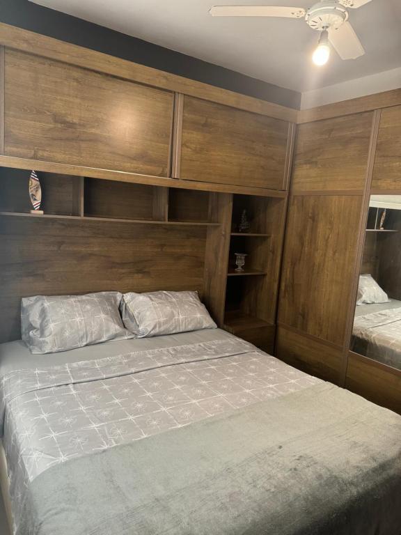阿拉亚尔-杜卡布Serra Mar Suítes,Lofts, e casas à 300 metros das praias的一间卧室设有一张床和木墙