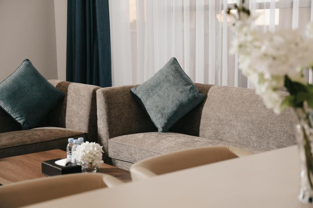 阿可贺巴Dream Residence Rawabi-دريم رزيدنس الروابي的客厅配有带2个枕头的棕色沙发