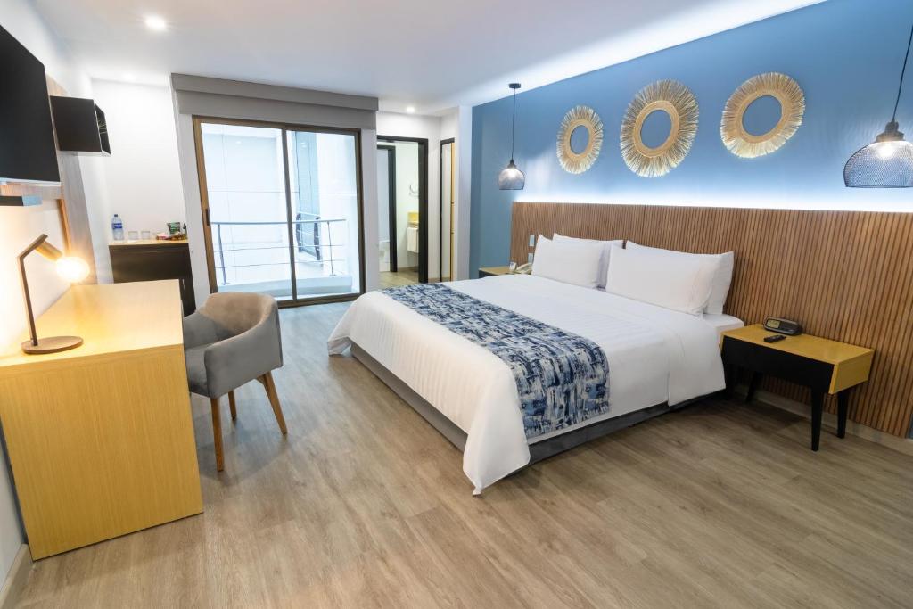 佩雷拉阿巴迪亚广场GHL酒店的酒店客房设有一张大床和一张书桌。
