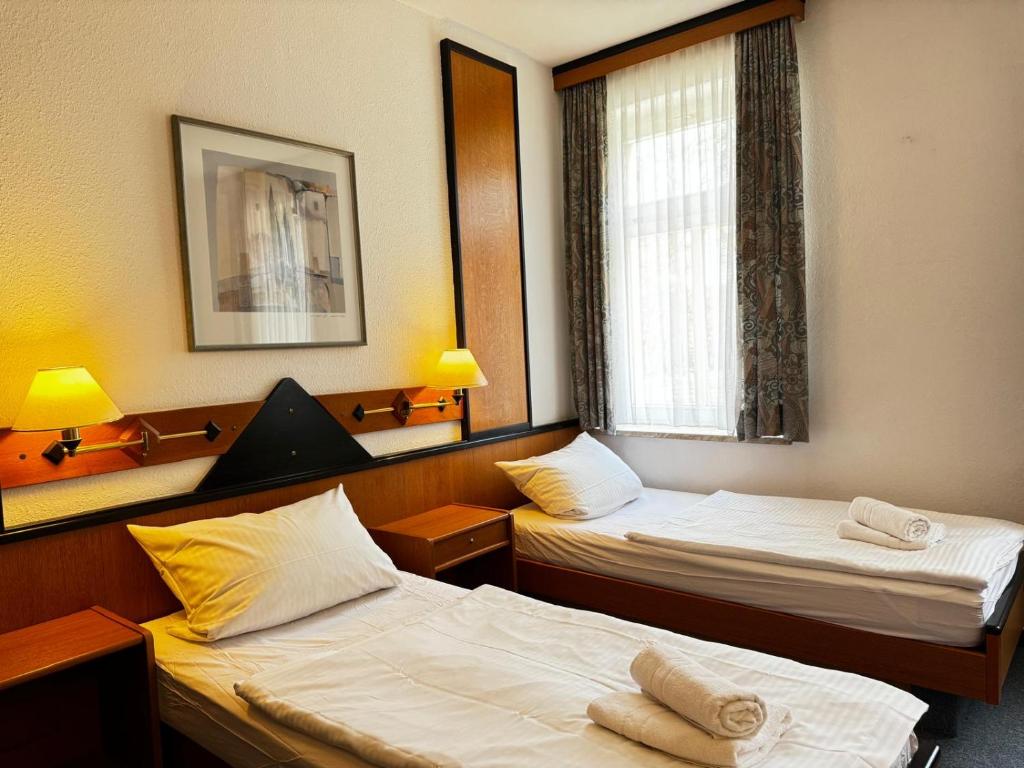 梅拉内Hotel zur Eiche的客房设有两张床和窗户。