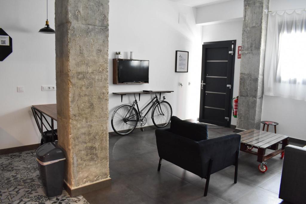 塞维利亚Sevilla Industrial Flat的一间带自行车、桌子和电视的客厅