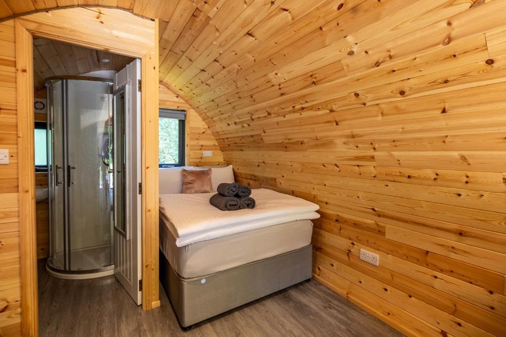 科克Mount Hillary Holiday Pods的小木屋内的一个带淋浴和一张床的房间