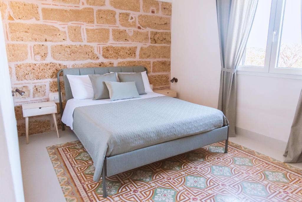 里里耶沃Cocci di tufo Appartamenti的一间卧室设有一张床和砖墙