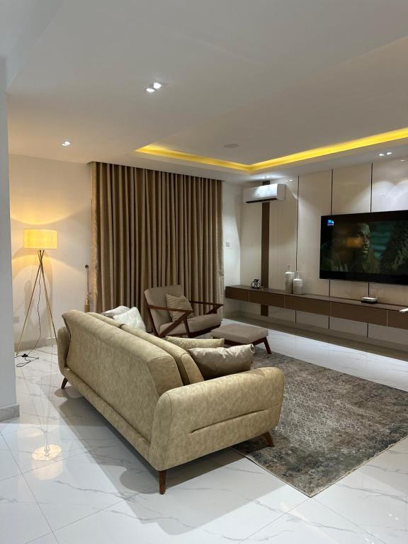 哈科特港Numdor Apartments By The Bond的带沙发和平面电视的客厅