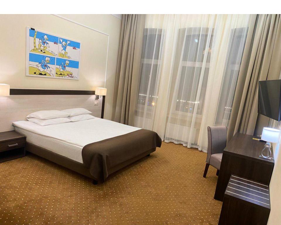敖德萨Hotel Donald的酒店客房配有一张床、一张桌子和一把椅子。