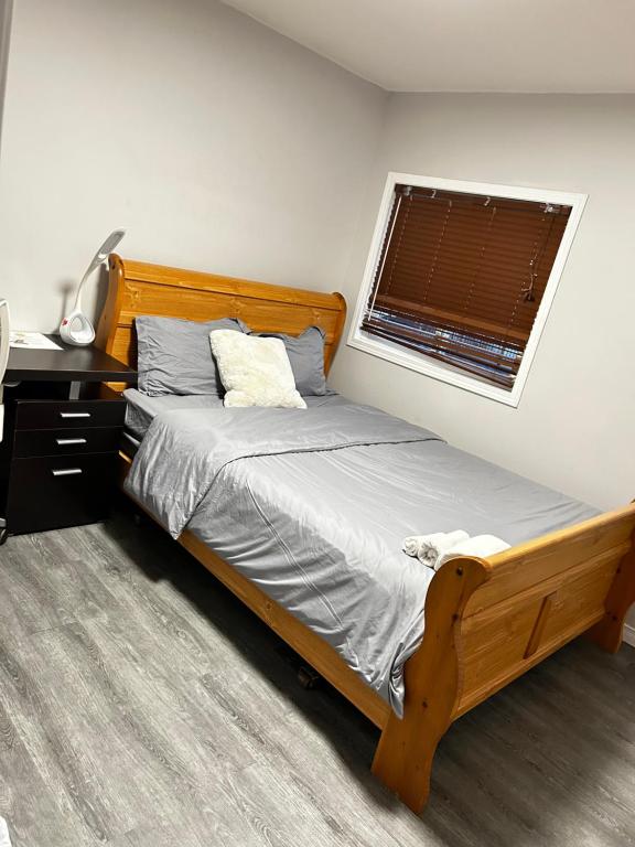 基奇纳Cozy room D的一间卧室设有一张木床和一个窗户。