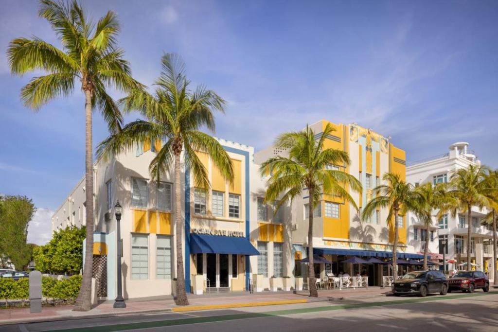迈阿密海滩海洋五号酒店的一条种有棕榈树的街道和一座黄色的建筑