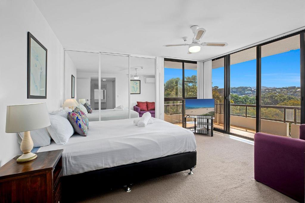 科夫斯港太平洋塔海滩度假酒店的一间带大床的卧室和一个阳台